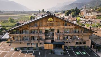 Un hôtel à plusieurs étages, doté d’une façade en bois, de balcons et d’un parking.