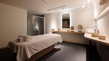 Relax in a serene space with a neatly made bed, large mirror, and convenient bedside table.