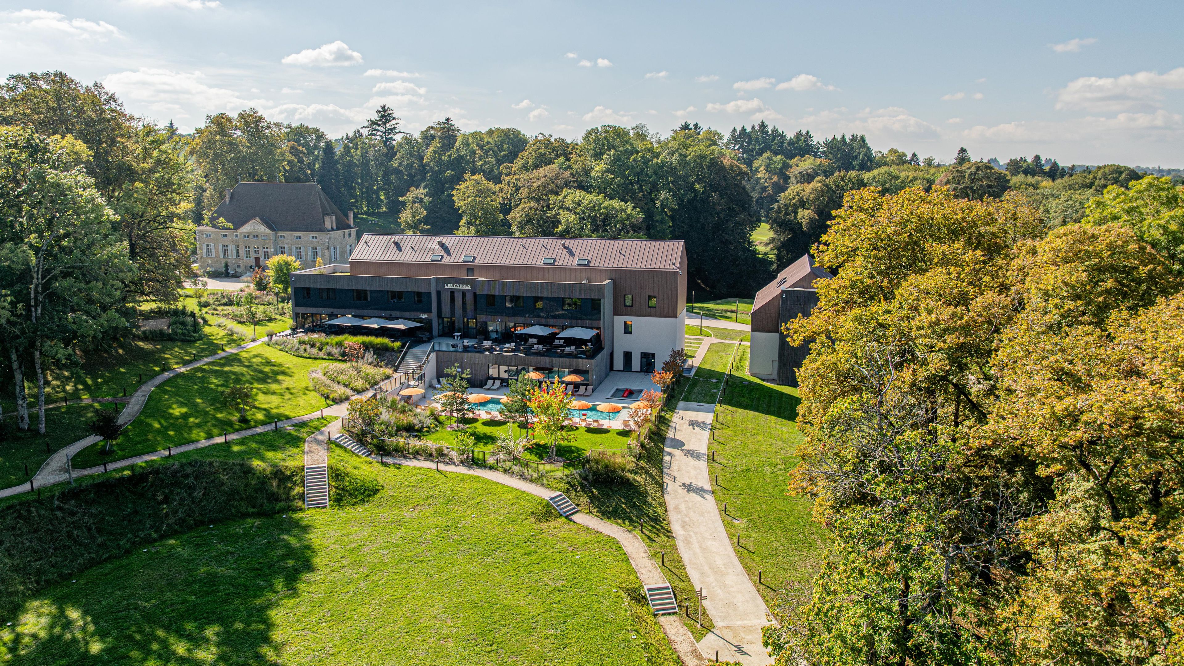 A modern building with a swimming pool and outdoor seating area.