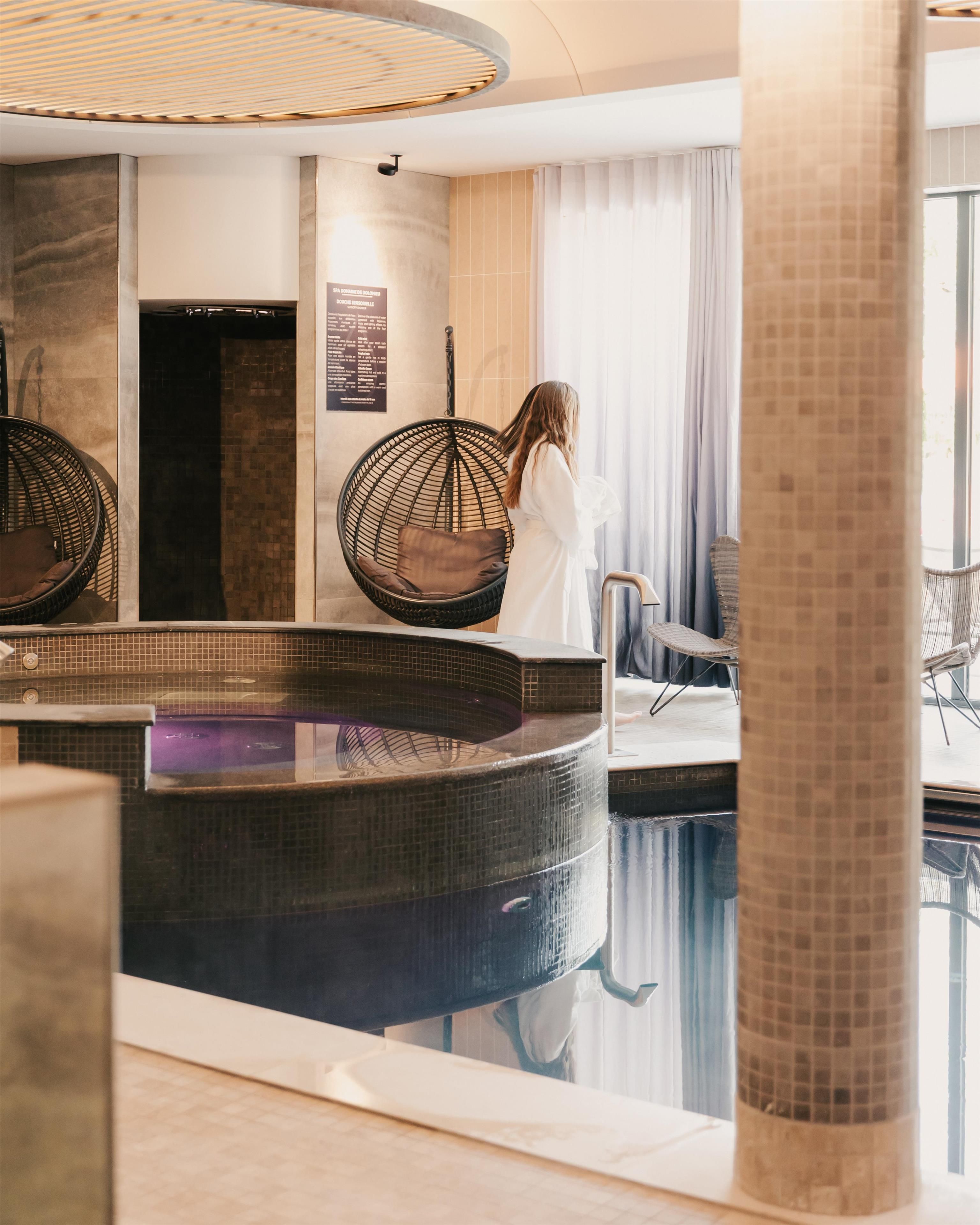 Et spaområde med jacuzzi, siddepladser og et skilt monteret på væggen.