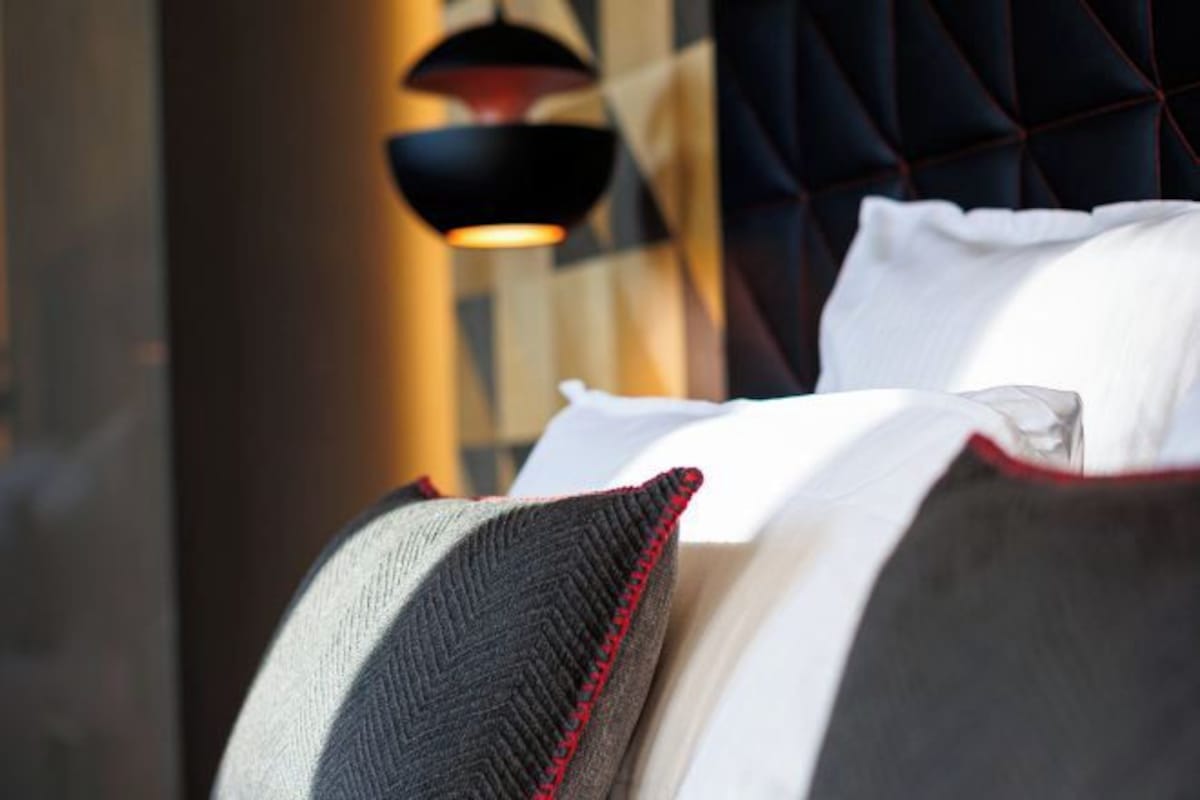 A bed with a dark headboard and white bedding.