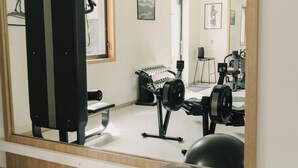Un gimnasio con equipo de ejercicio, un espejo y pelotas de entrenamiento.