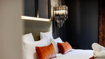 Une chambre d’hôtel avec un lit, des oreillers, une table de chevet, une lampe et une fenêtre.