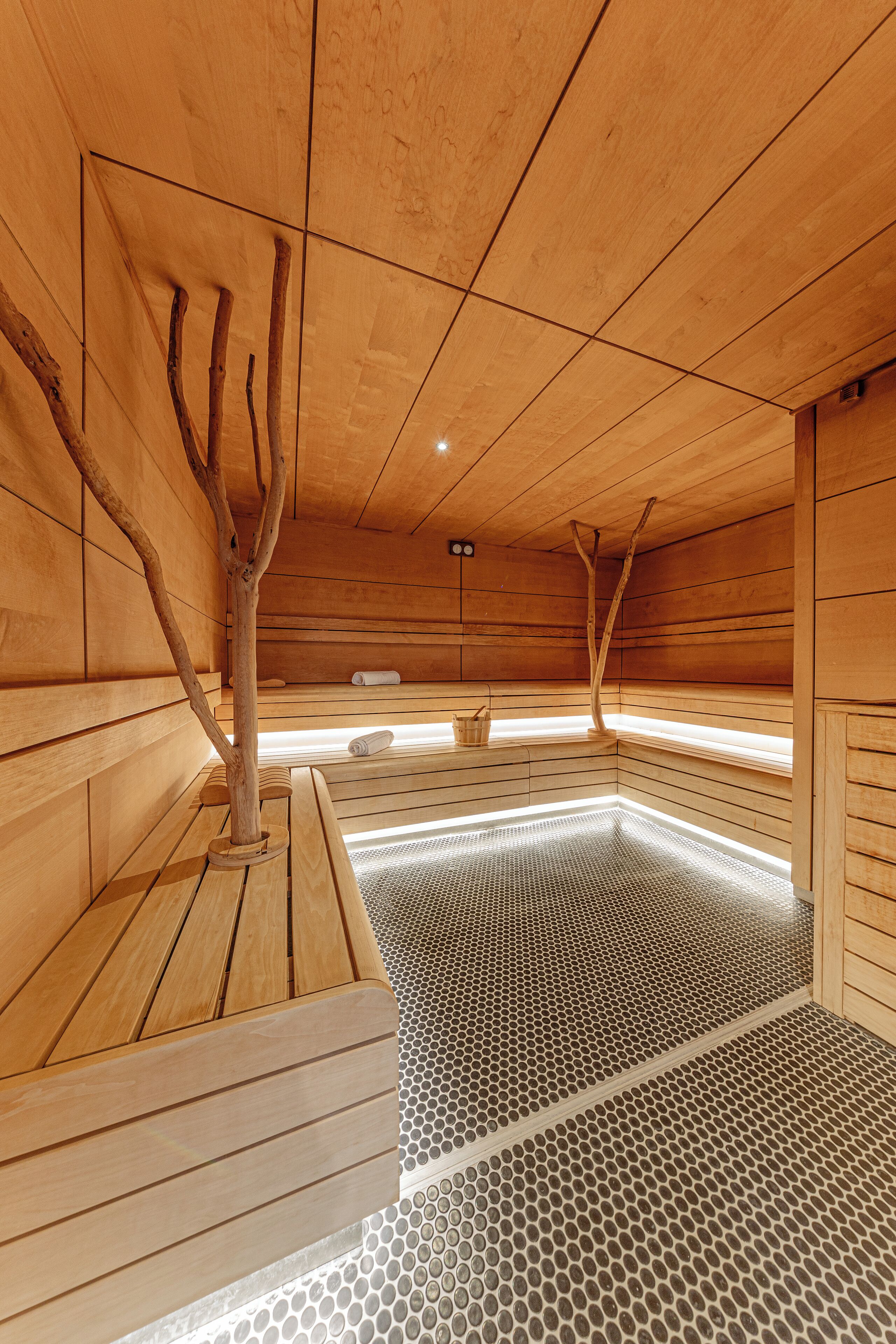 A sauna with wooden benches and a tiled floor.