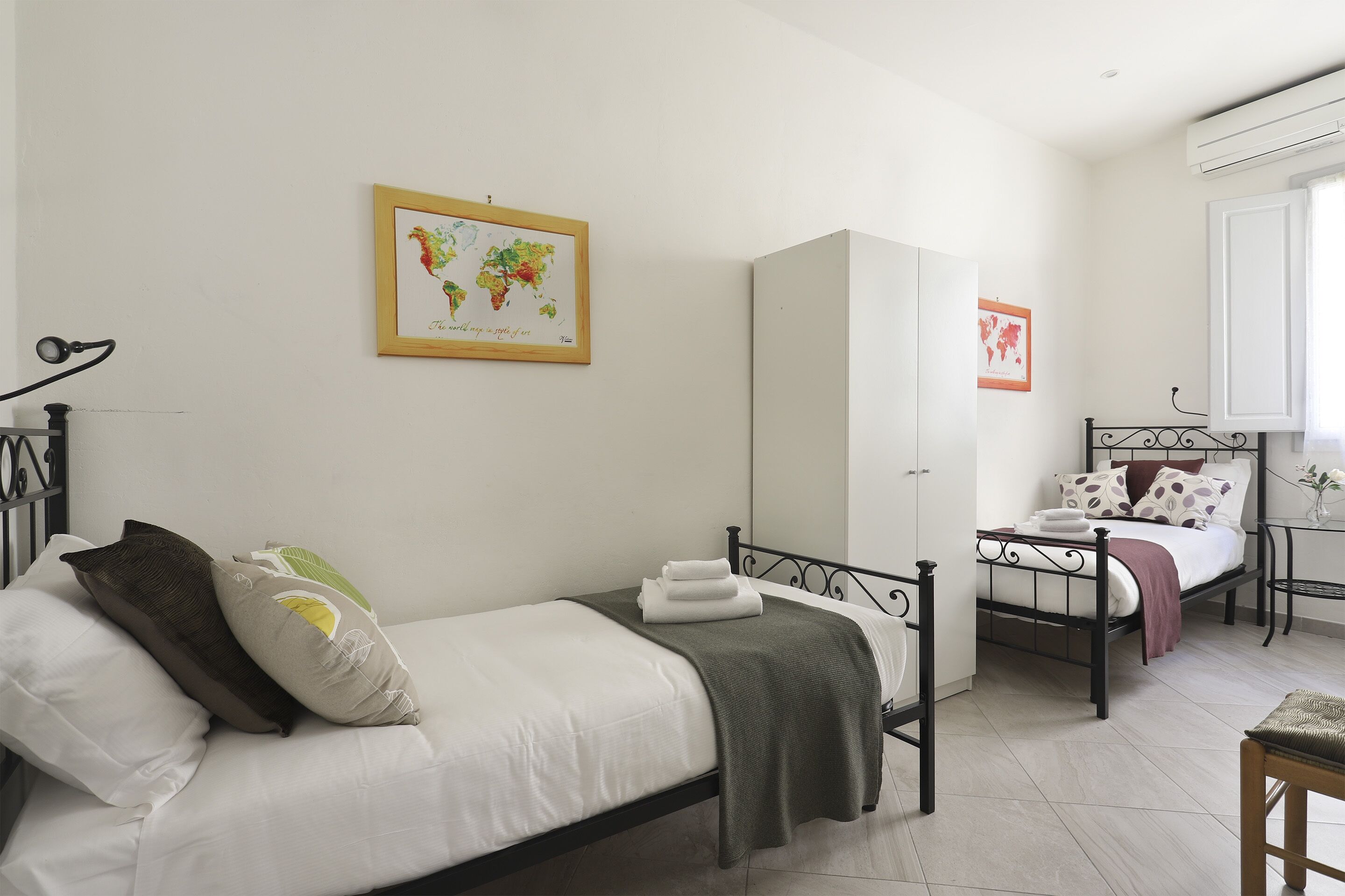 A bedroom with a bed, a wardrobe, a desk, and a chair.