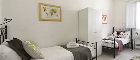 A bedroom with a bed, a wardrobe, a desk, and a chair.