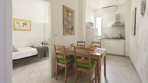 A compact kitchen with white cabinets, a microwave, and a gas stove. - At 4 for you (Florence)