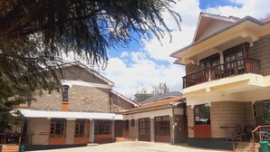 Un patio con un edificio que tiene un balcón y un letrero que dice "Kilimanjaro House".