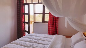 A bed with white bedding in a room with a window, red curtains, and a white canopy. - Merinja Guest House (Naivasha)