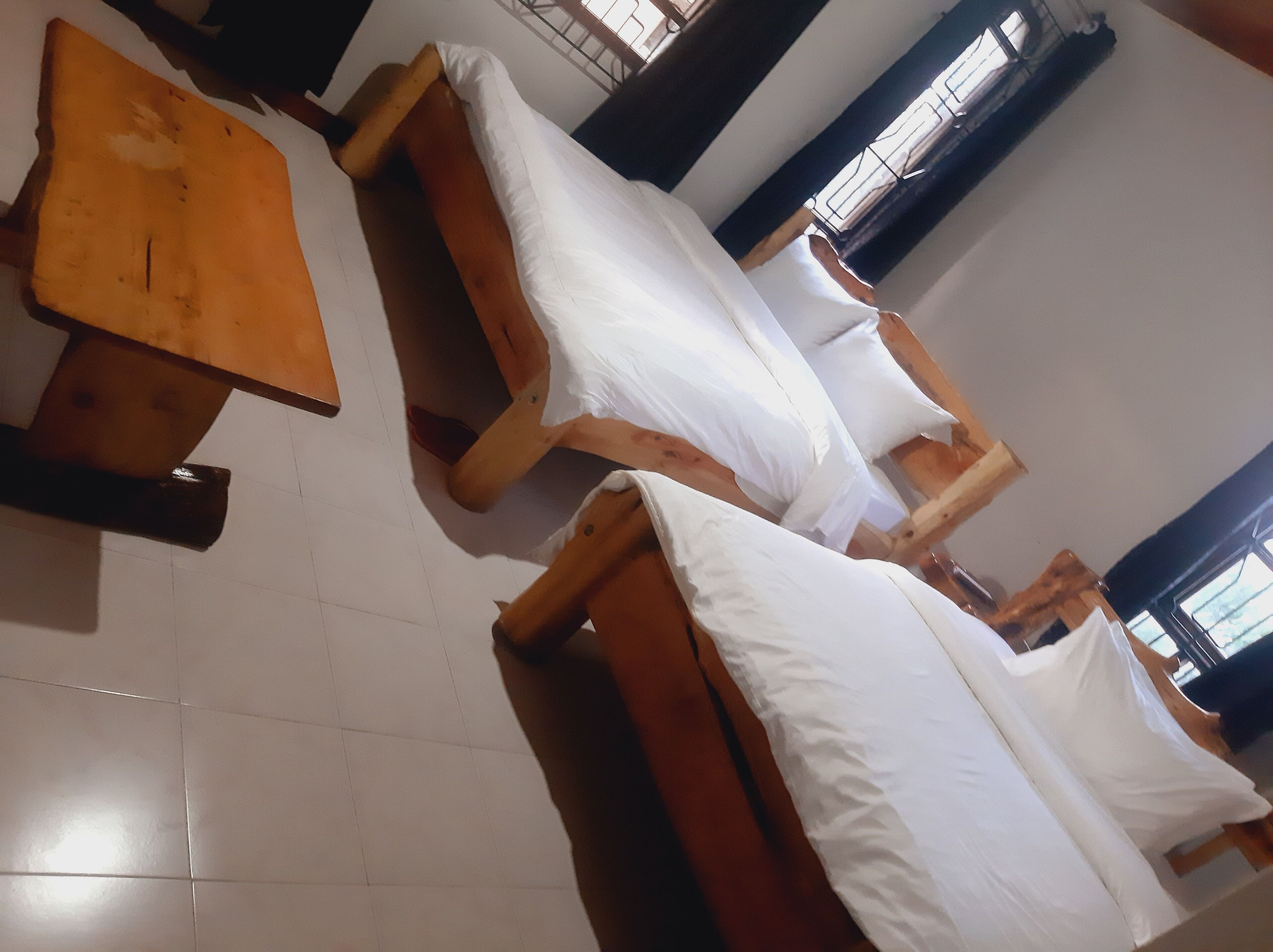 Una habitación con camas y una mesa de madera.