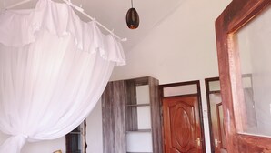 Un dormitorio con cama a dosel, armario de madera y puerta de madera.