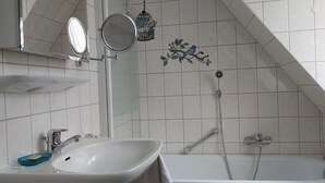 Une salle de bain avec un lavabo, un miroir et une douche.