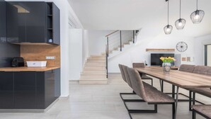 A modern kitchen with dark cabinets, a wooden countertop, and a built-in oven.