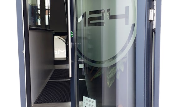 A hotel entrance with a glass door, a sign indicating 'Boardinghaus & Hotel Hinleeringang', and a small sign with a warning. - Hotel M24 (Vechta)