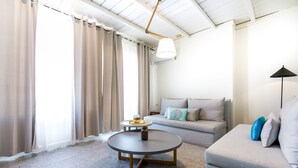 Uma sala de estar moderna com uma mesa de centro redonda, um sofá e uma luminária.