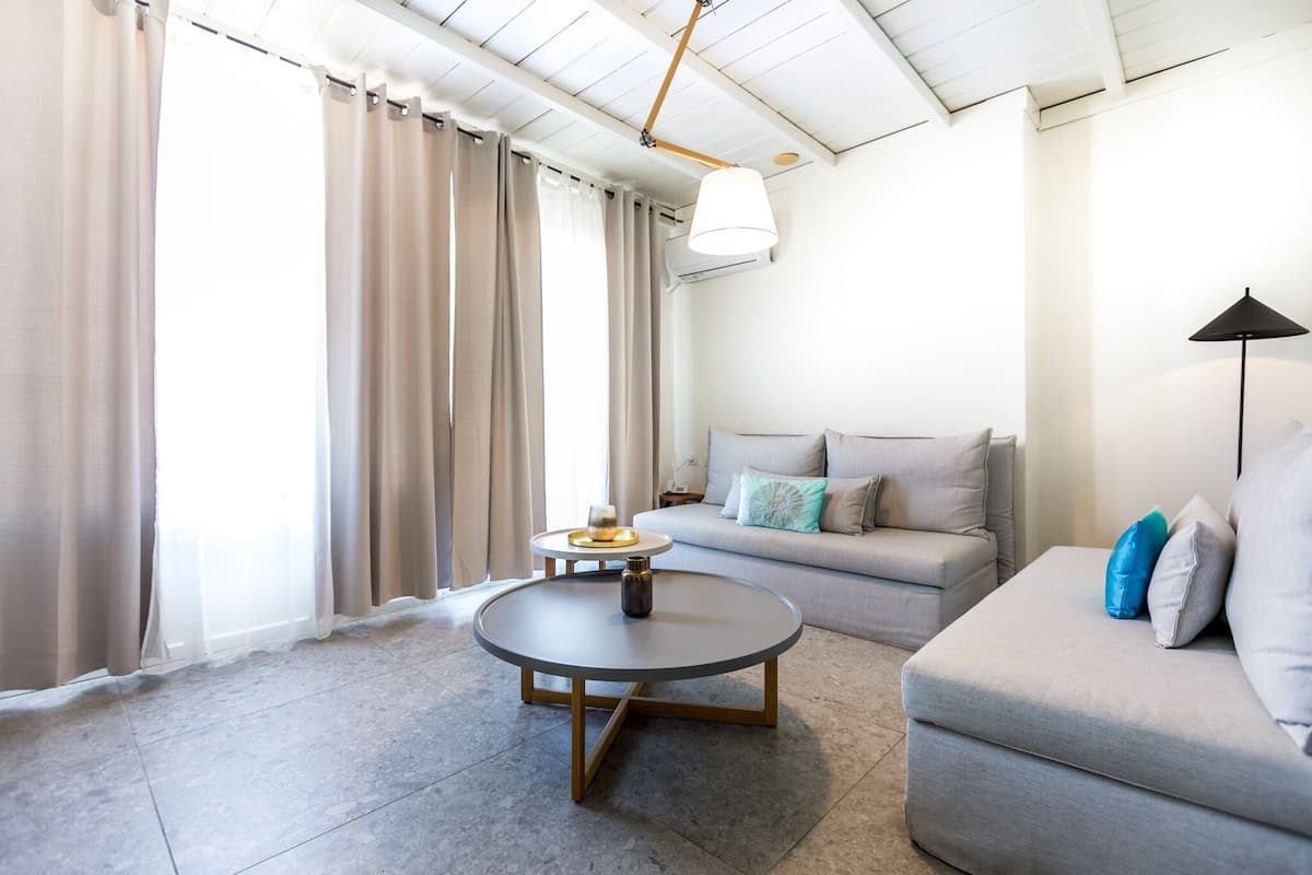 A modern living room with a round coffee table, a sofa, and a lamp.