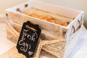 A wooden crate with a label that reads "Fresh Eggs" and a lace ribbon.