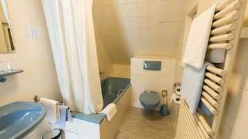 A bathroom with a bathtub, toilet, sink, and towel rack.