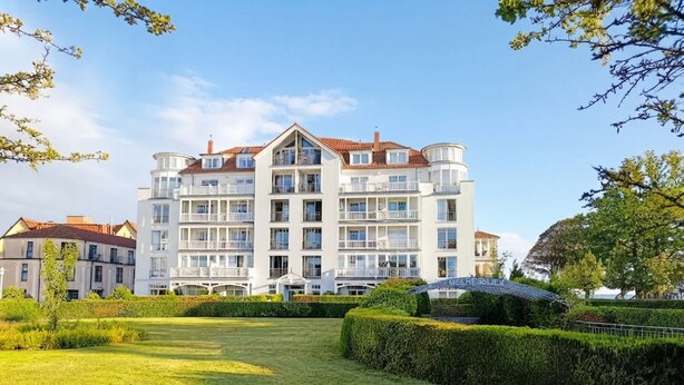 A multi-story hotel with balconies, a well-maintained lawn, and a clear sky. - House Meeresblick WM319 - WM319 (Kühlungsborn)