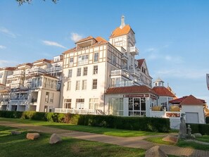 Un immeuble à étages doté d’un style architectural traditionnel, caractérisé par une tour imposante et de nombreux balcons.