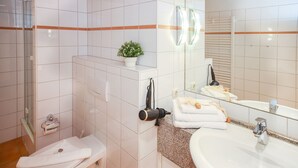 A modern bathroom with a shower, toilet, sink, and a mirror. - House Meeresblick WM319 - WM319 (Kühlungsborn)