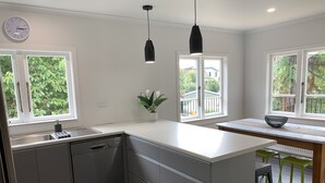 Una cocina moderna con lavavajillas, un lavaplatos y un comedor con una mesa y sillas.