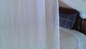 A bed with a canopy and a pillow. - Check Point Guest House (Isinya)