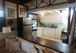 A living room with a sofa and a kitchen in the background.