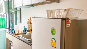 Une cuisine moderne avec des meubles en bois, un réfrigérateur en acier inoxydable et un four encastré.