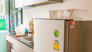 Cozinha moderna com armários de madeira, geladeira de aço inoxidável e forno embutido.