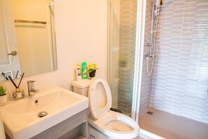 A bathroom with a sink, toilet, and shower.