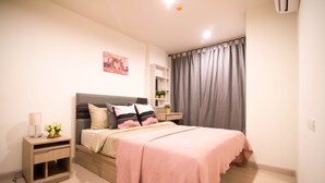 Een moderne slaapkamer met een bed, nachtkastjes en een raam met gordijnen.