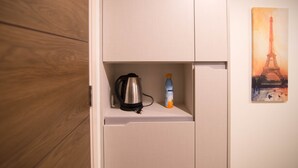 Een witte kast met een waterkoker en een waterfles erop.
