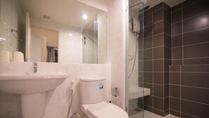 Een moderne badkamer met toilet, wastafel en douchecabine met glazen wanden.
