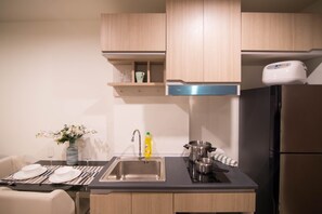 A modern kitchen with a stainless steel sink, a built-in oven, and a refrigerator.