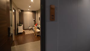 Ein Hotelzimmer mit Holzboden, einem karierten Teppich, einem Esstisch mit Stühlen und einer blauen Wand.