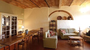 Una sala de estar acogedora con una mesa de comedor de madera, dos sofás y una estantería.