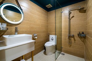 Ein modernes Badezimmer mit einem weißen Waschbecken, einer Toilette und einer Duschkabine.