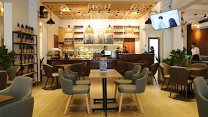 A cafe with a wooden ceiling, a bar area, and seating arrangements. - Apro Aparthotel Saigon Center (Ho Chi Minh City)
