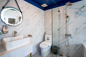 A bathroom with a white sink, a toilet, and a shower with a glass door. - Apro Aparthotel Saigon Center (Ho Chi Minh City)