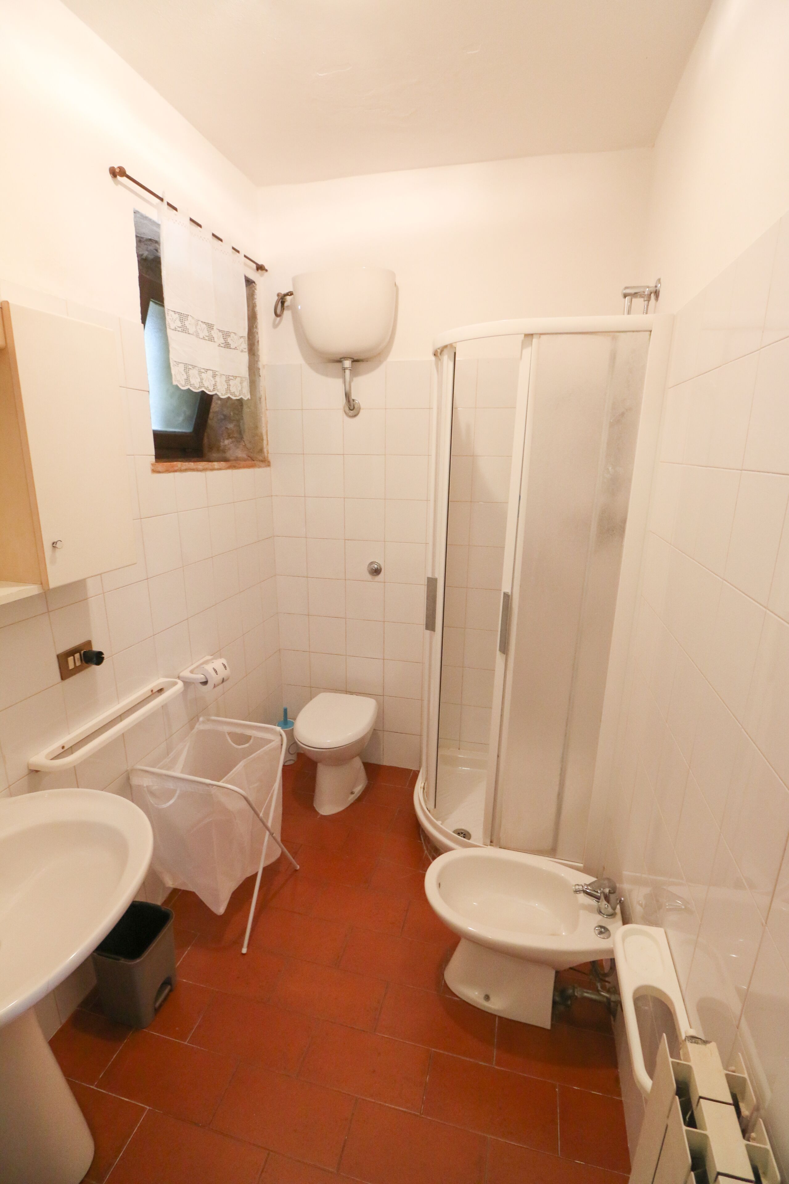 A compact bathroom with a toilet, bidet, and a shower enclosure.