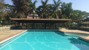 A rectangular swimming pool with a tiled deck surrounding it.