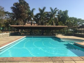 A rectangular swimming pool with a tiled deck surrounding it.