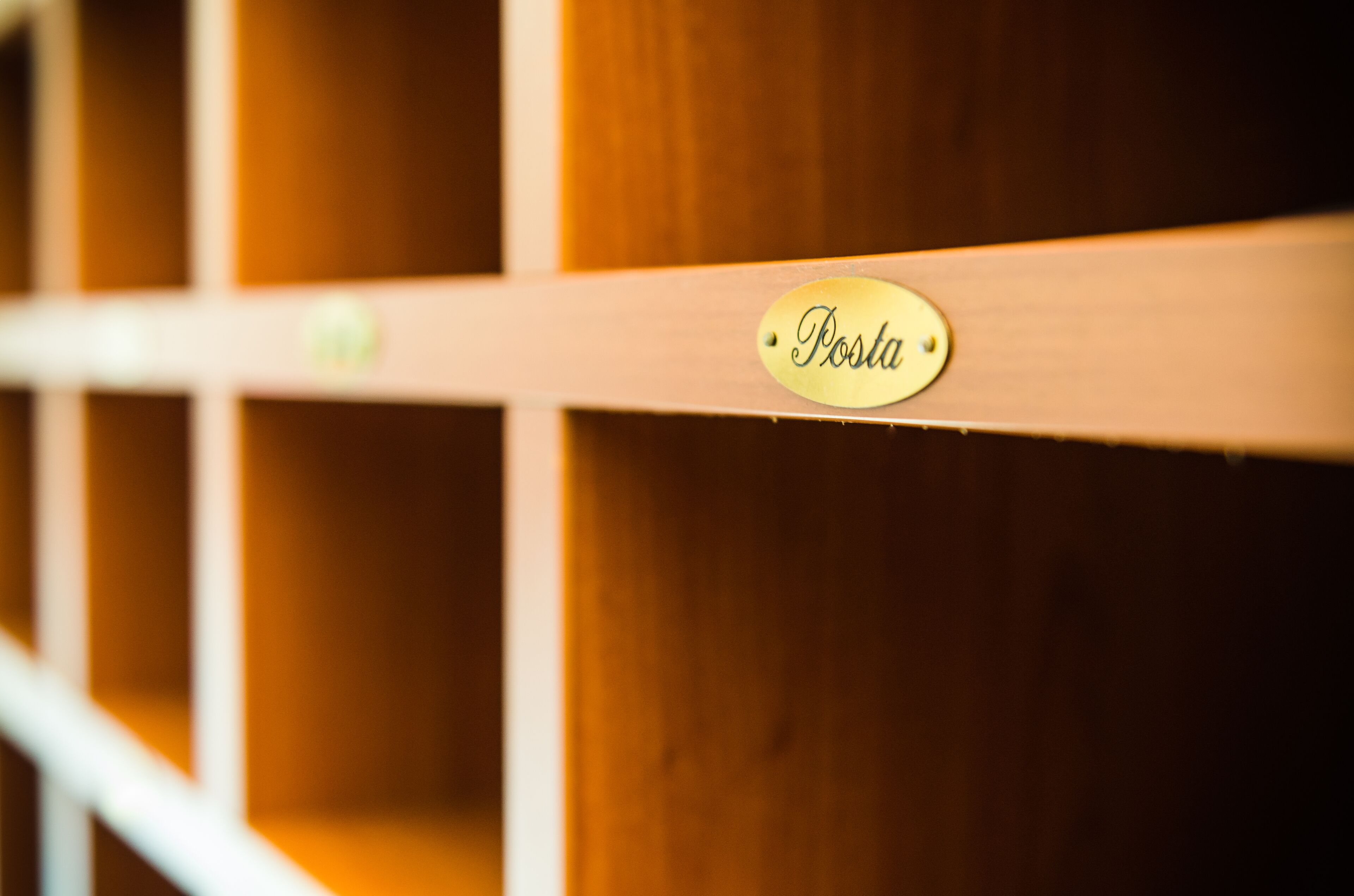 Una estantería de madera con una etiqueta que dice "Posta".