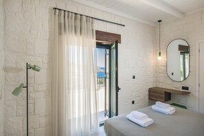 A bedroom with a bed, a bathroom with a mirror, and a view through a door. - Sea View Villa with Private Pool | West Crete (Kissamos)