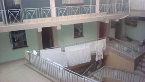 A multi-level residential building with balconies, staircases, and a laundry area. - Palin Hotel (Mwingi)