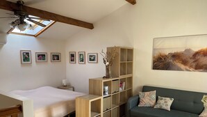 A cozy room with a bed, a sofa, a small table, and a bookshelf. - House for rent 50 m from the beach (Le Barcarès)