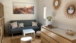 A modern living room with a grey sofa, a white coffee table, and a wooden cabinet. - House for rent 50 m from the beach (Le Barcarès)