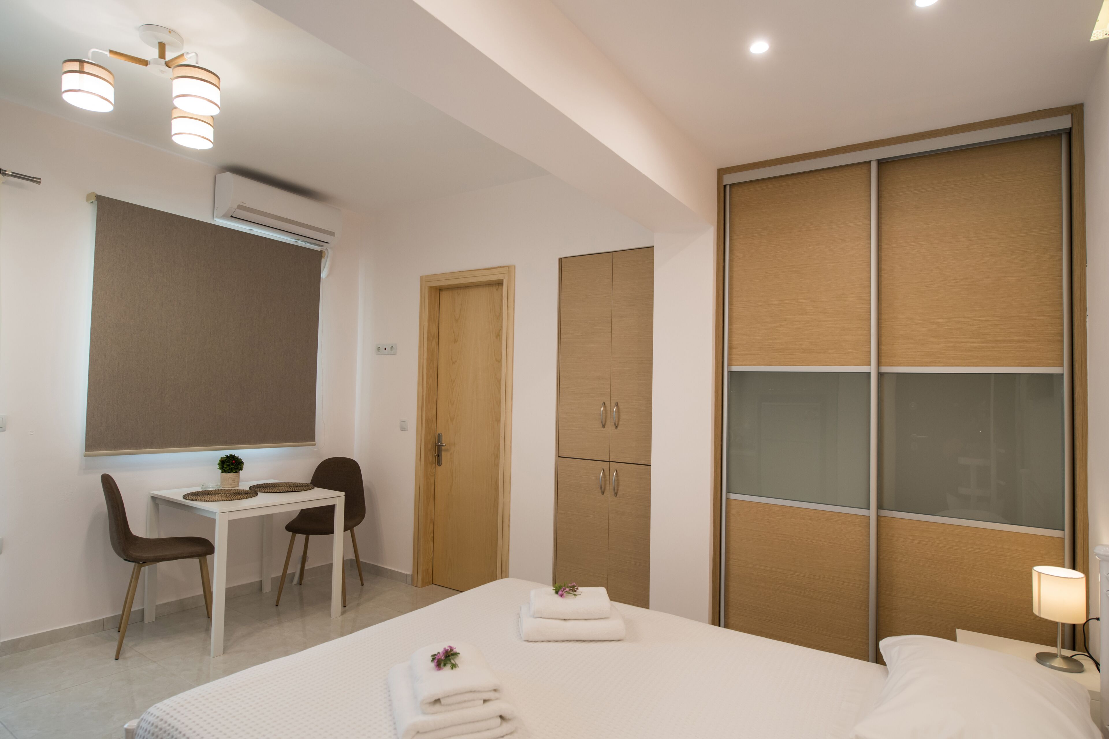 Una habitación de hotel moderna con cama, mesita de noche, escritorio y sillas.