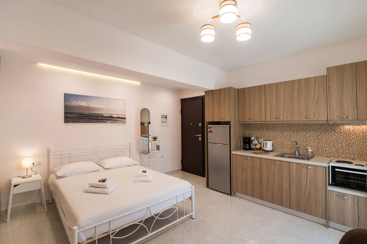 Um quarto moderno com uma cama, mesa de cabeceira e criado-mudo.